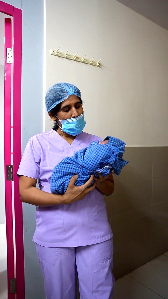 Staff holding newborn at Mother Hospitals Hyderabad